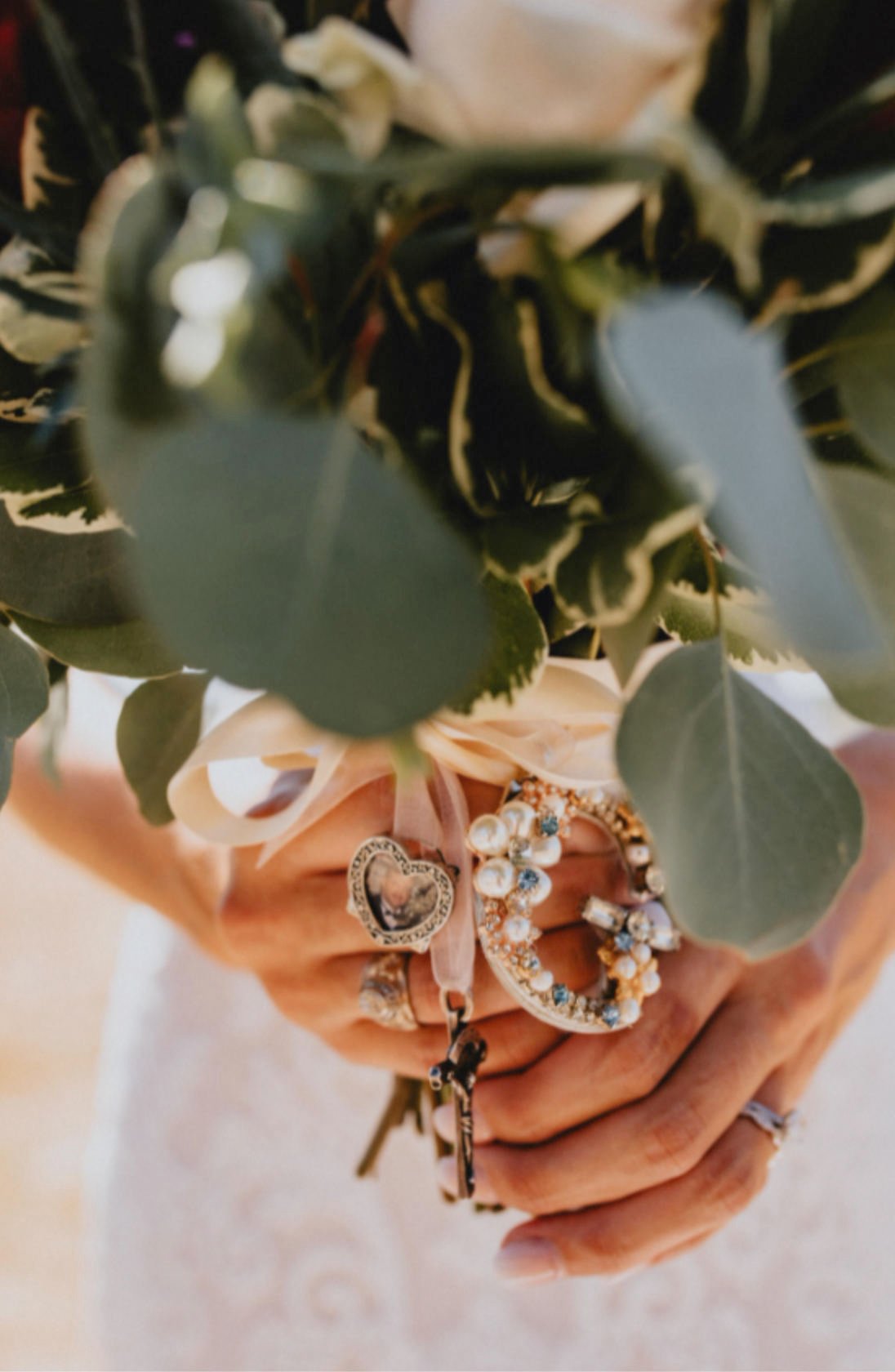 Closeup of a wedding bouquet with various charms dangling from it, depicting a sample bouquet from weddings in Fredericksburg TX
