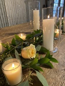 A closeup of candles and floral provided by A Better Fete for a wedding in Fredericksburg TX