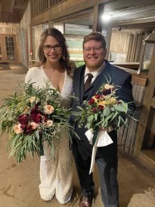 A bride and groom holding wedding bouquets and smiling, showing the joy of weddings in Fredericksburg TX