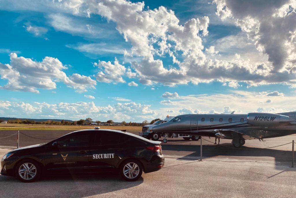 A security car next to a plane on a bright sunny day