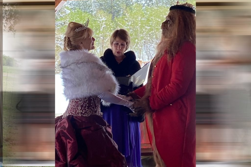 A female minister in a fur coat marries a bride and groom who are dressed up as Belle and Beast. They represent unique wedding officiants in Fredericksburg TX.